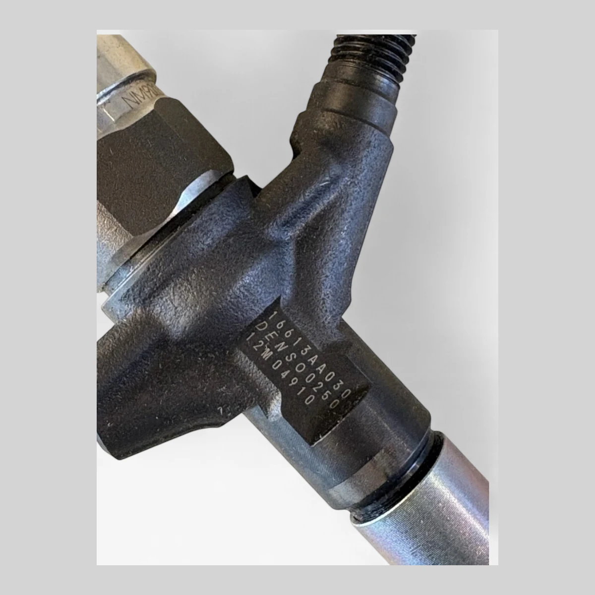 DENSO DCRI300250 diesel injector part-number close-up (16613AA030 DENSO / 12M 04910)