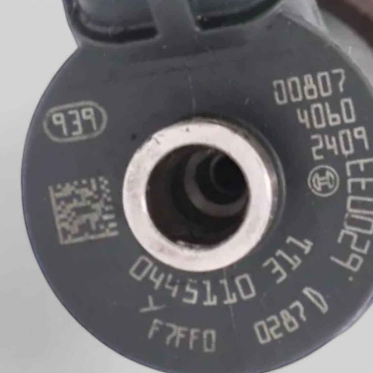 Bosch 0445110311 diesel injector laser etching close-up showing Bosch part number