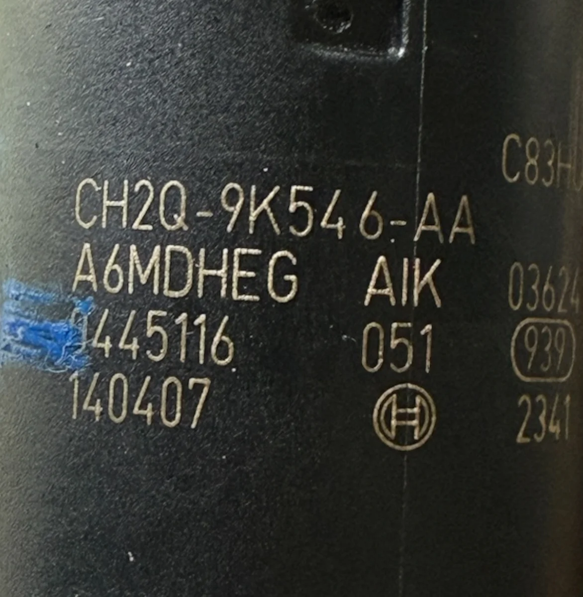 Close-up of CH2Q-9K546-AA and Bosch 0445116 051 part number markings on 0445116051 injector